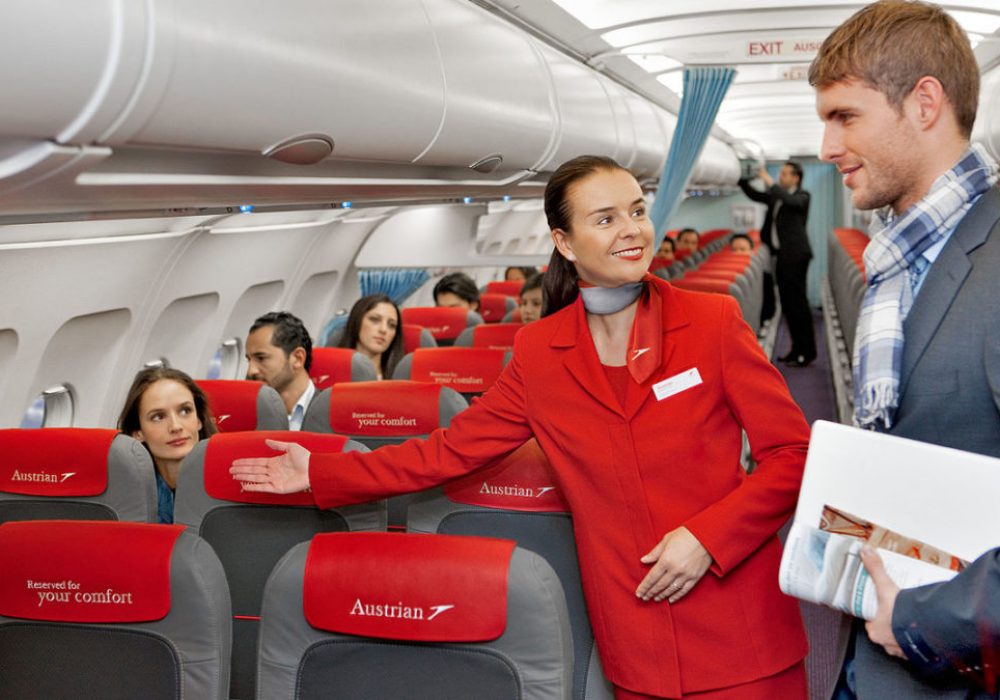 1200px-Austrian_Airlines_flight_attendant_and_passenger-1080x675